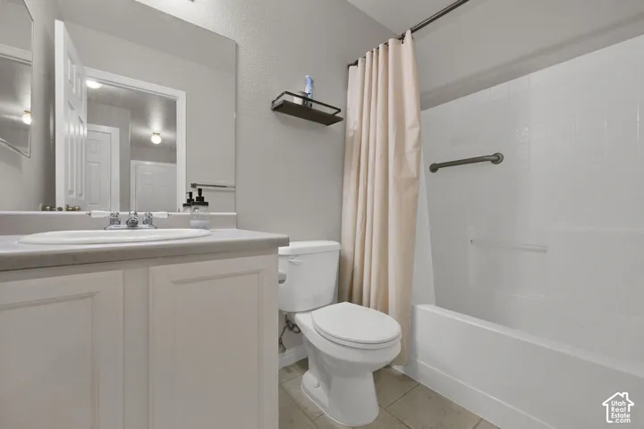 Main Bathroom with vanity with integrated sink, chrome-finish faucet, and white cabinetry. Tub/shower combo