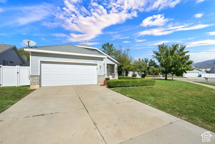 Attached two-car garage, light-colored siding, and stone accents