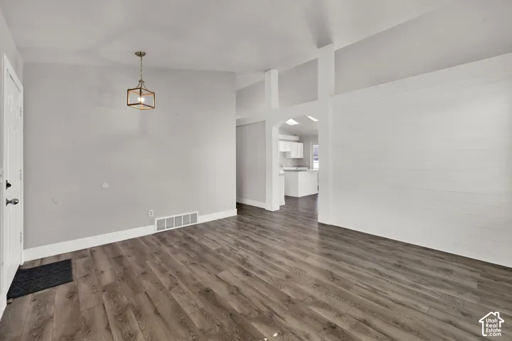 Wood-finish flooring, vaulted ceilings, and a contemporary ceiling light fixture