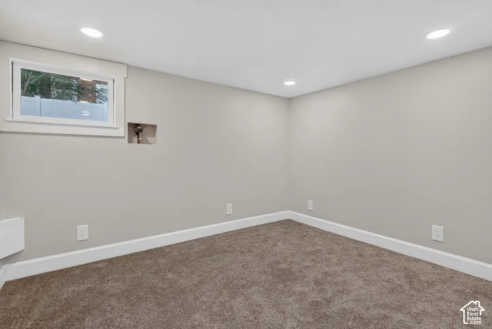 Neutral tone walls, recessed lighting, white trim, and a window with white casing