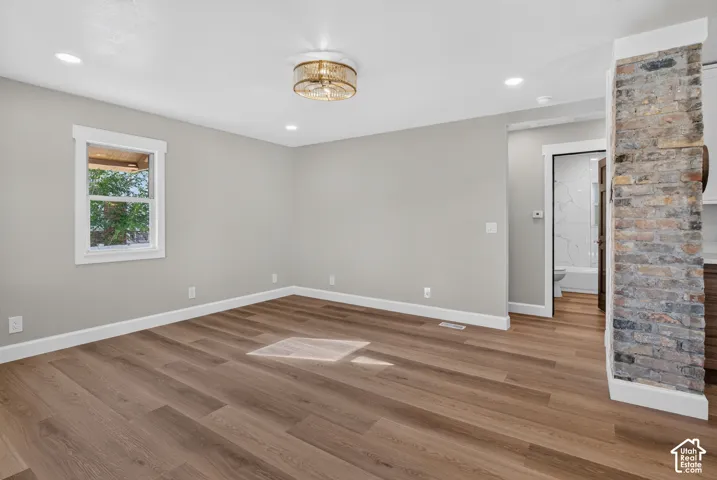 Wood-finish flooring, recessed lighting, and a decorative ceiling fixture