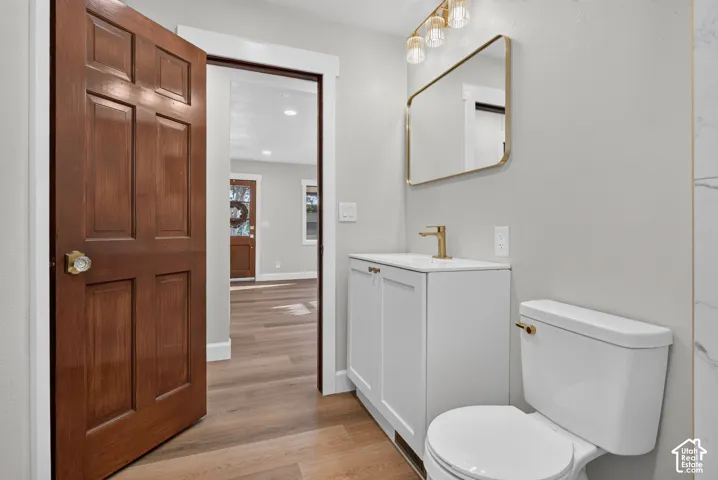 White vanity with gold-finish hardware, gold-finish faucet, and a rectangular mirror