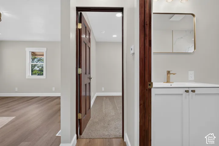 Bathroom vanity with a gold-framed mirror, gold-finish faucet, and white cabinetry