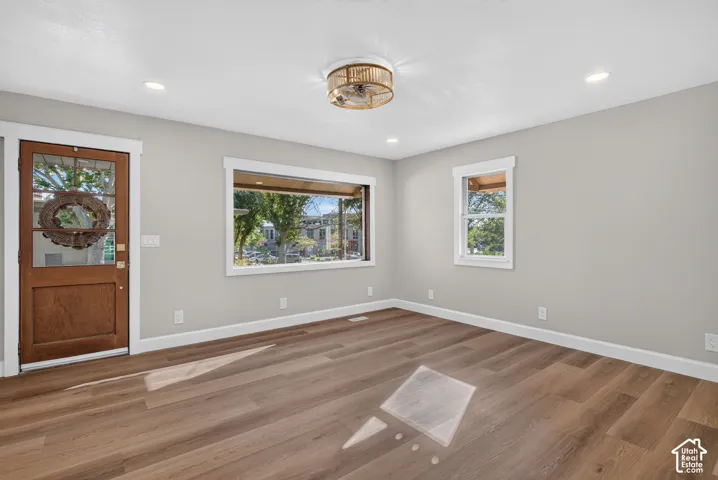 Wood-finish flooring, recessed lighting, and a decorative ceiling fixture