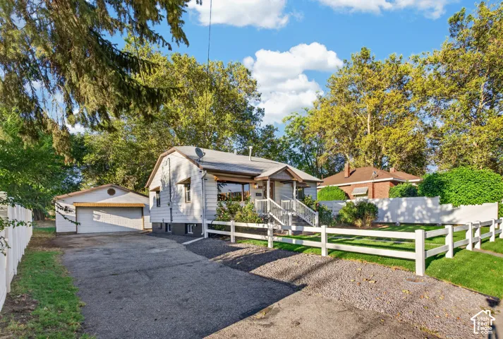 Exterior residence featuring white siding, a covered entry with steps, and a detached two-car garage