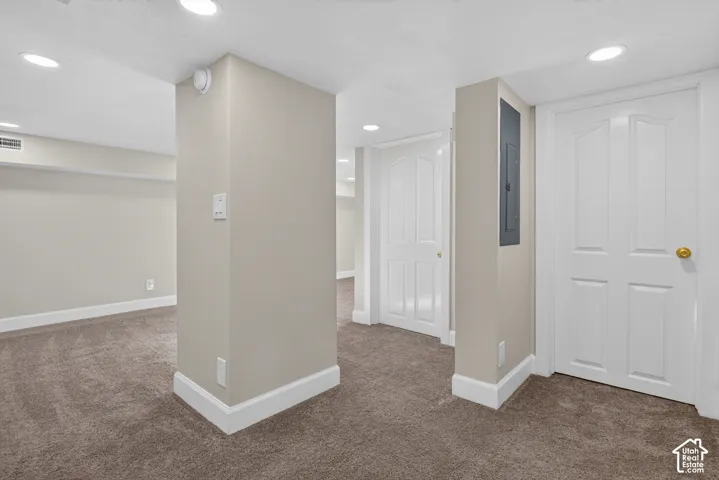 Recessed ceiling lighting, neutral-toned walls, and brown carpeting throughout