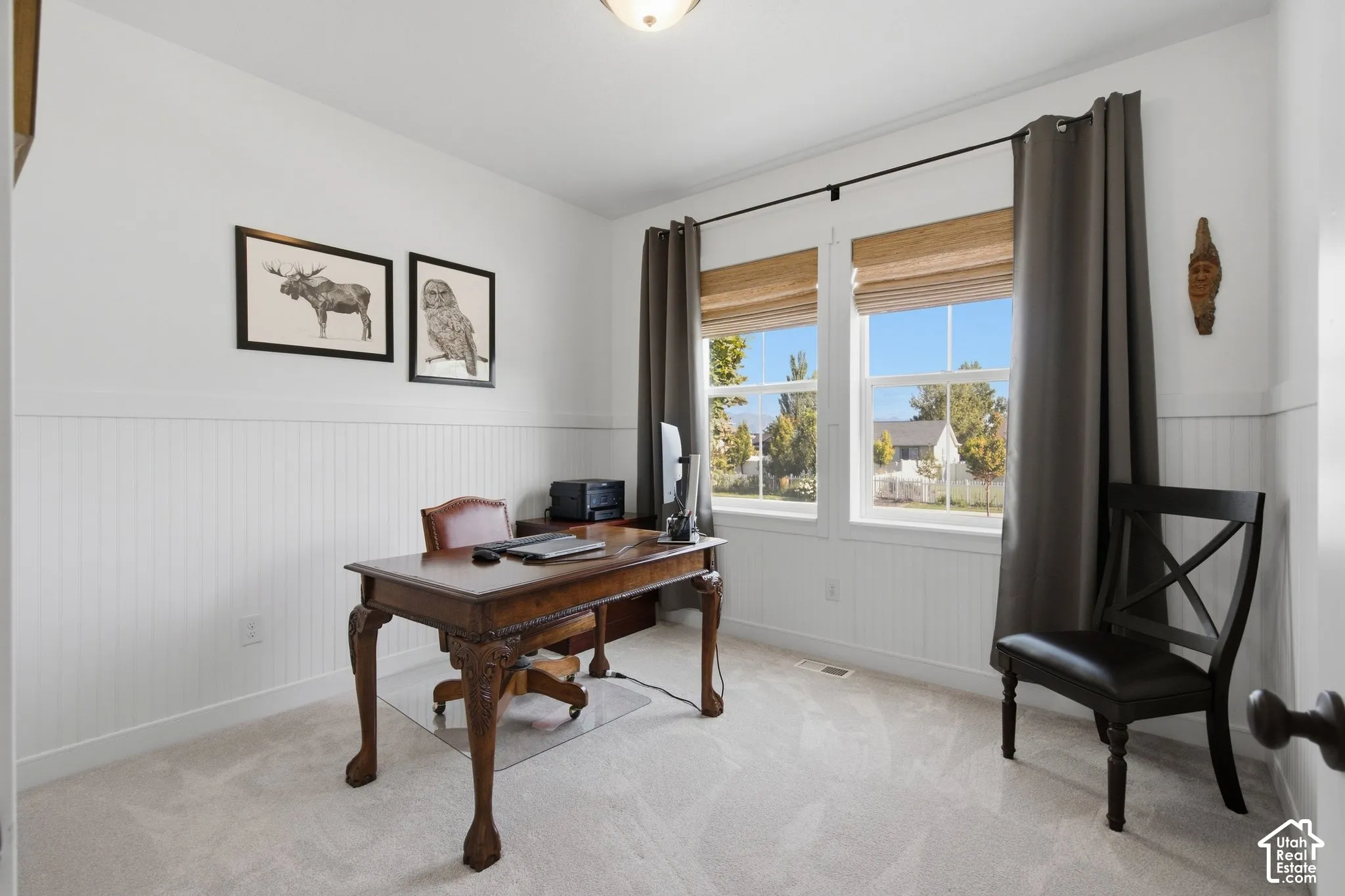 Dual windows, wall paneling, and neutral carpeting