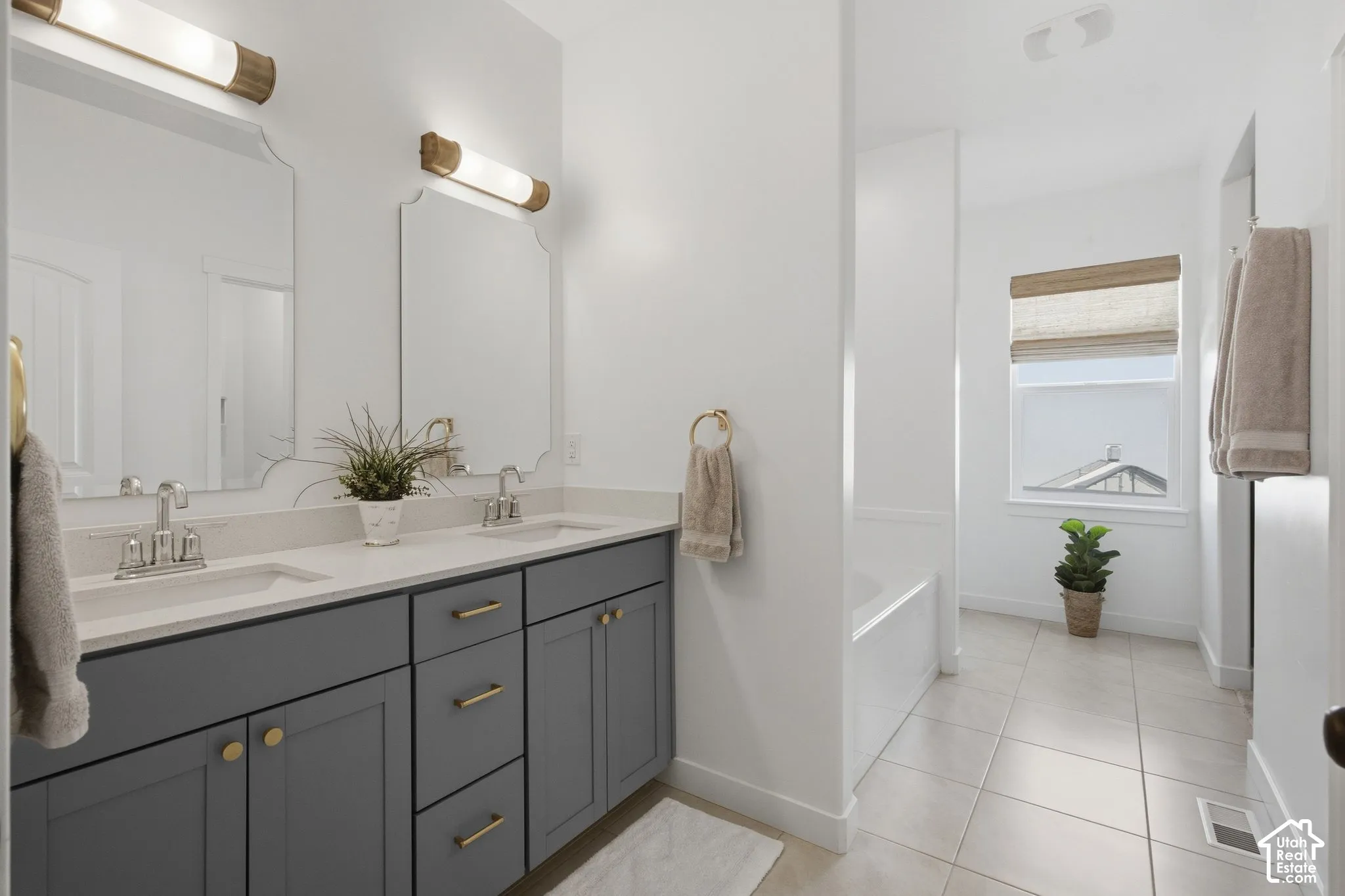 Dual vanity with gray cabinetry, white countertops, and brushed nickel faucets