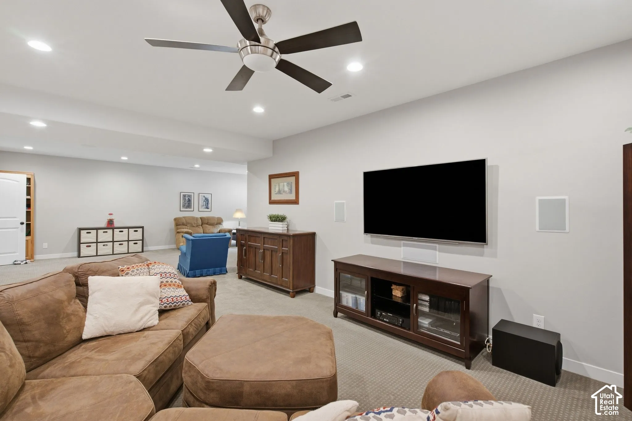 Recessed lighting, ceiling fan with brushed nickel finish, mounted television, and integrated wall speakers