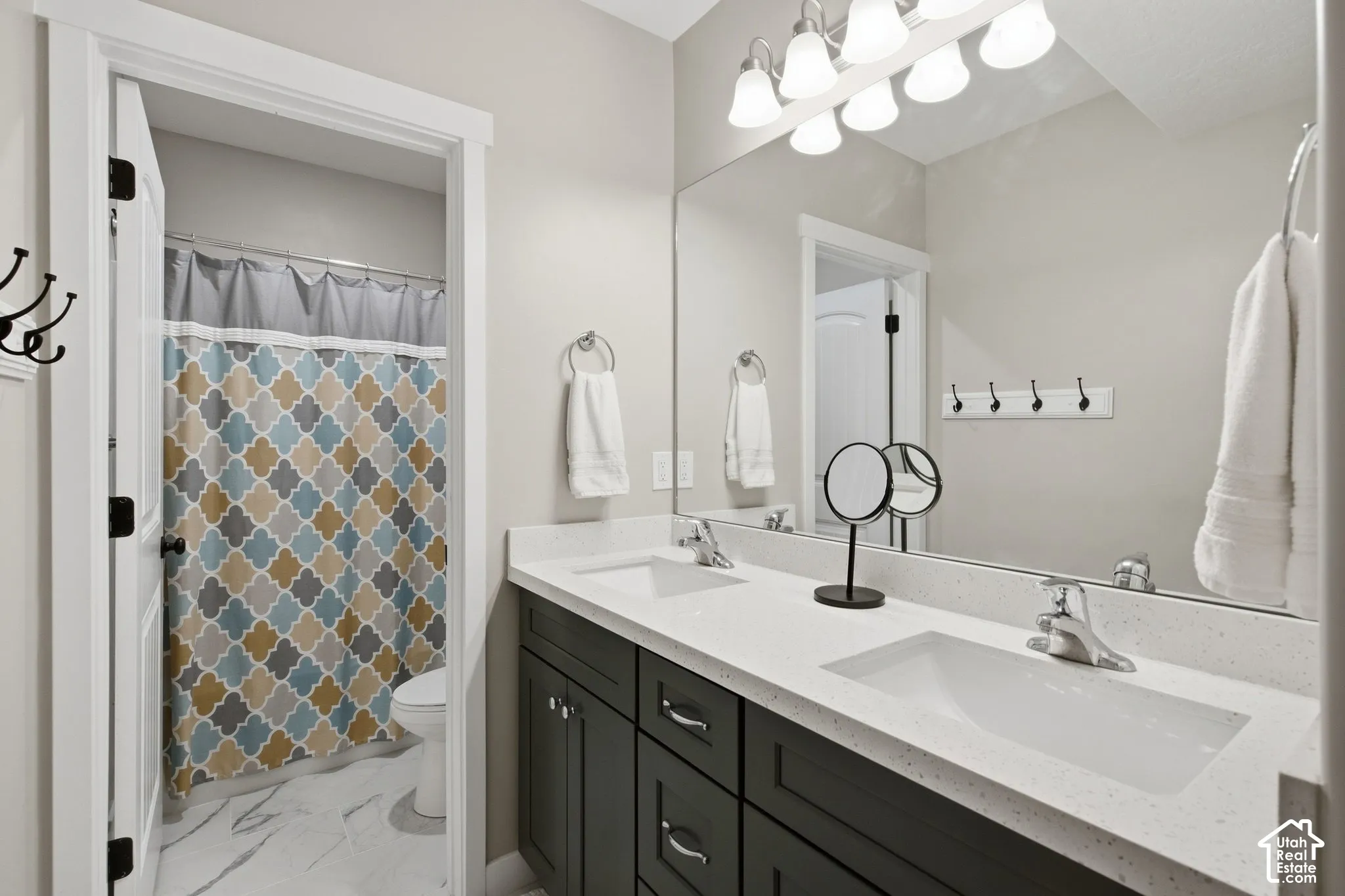 Dual vanity with white undermount sinks, light-toned countertop, and dark cabinetry