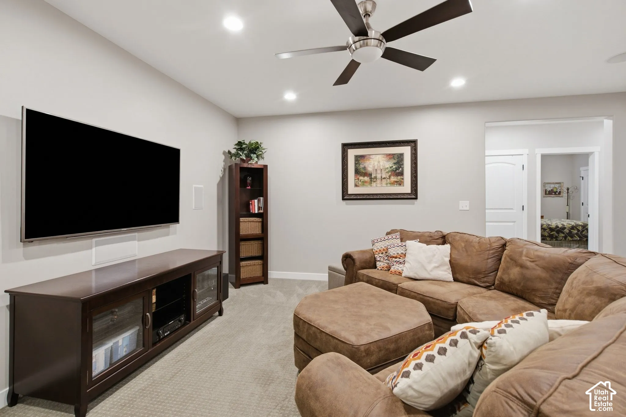 Recessed ceiling lighting, ceiling fan, neutral wall paint, and light-colored carpeting