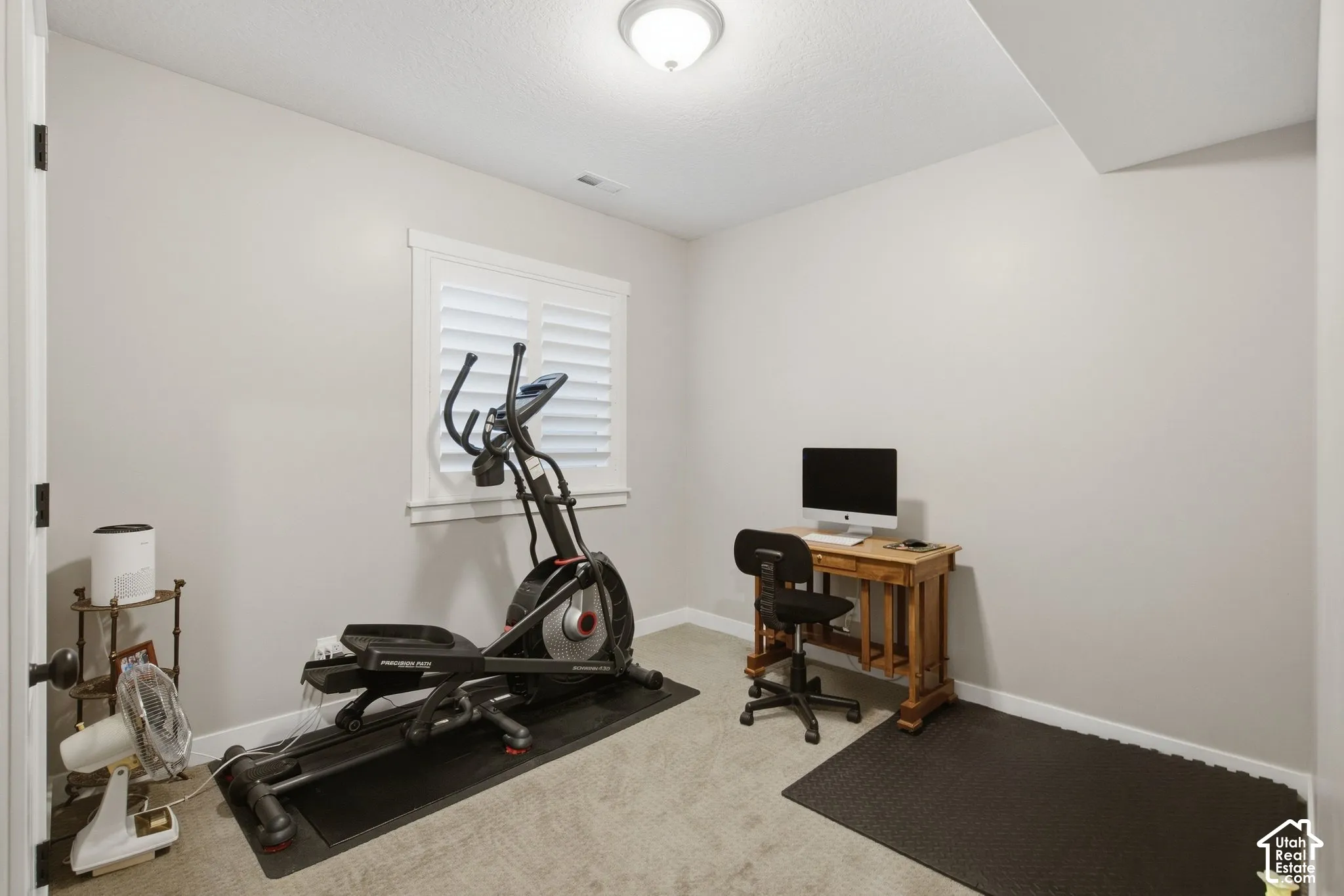 Recessed window with white plantation shutters, neutral wall color, and a ceiling-mounted light fixture