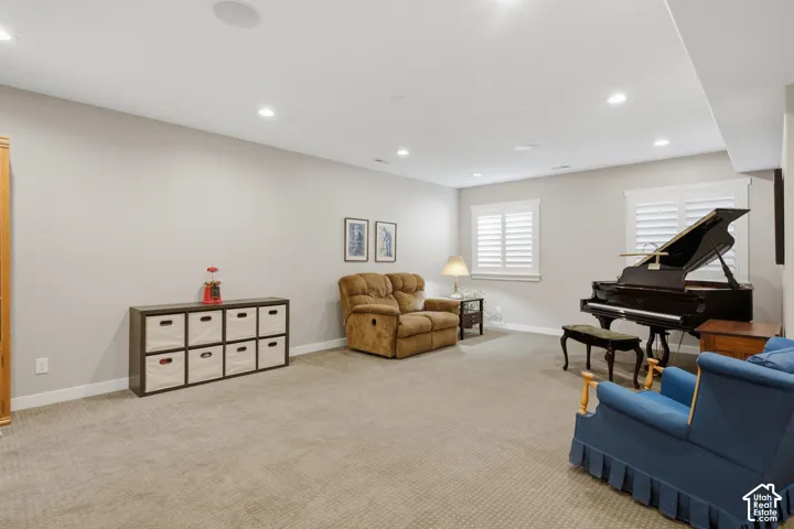 Recessed lighting, light gray wall paint, carpeting, white window shutters, and a built-in ceiling speaker