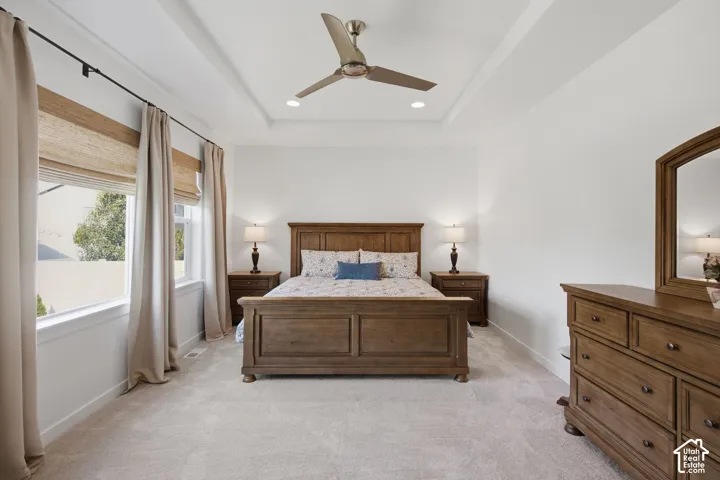 Recessed lighting, ceiling fan, and tray ceiling complement the neutral wall finishes