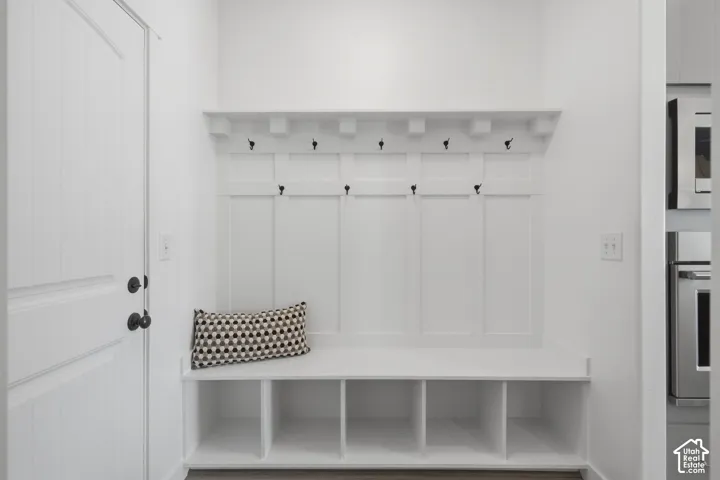 Built-in storage bench with cubbies, upper hooks, and a display shelf