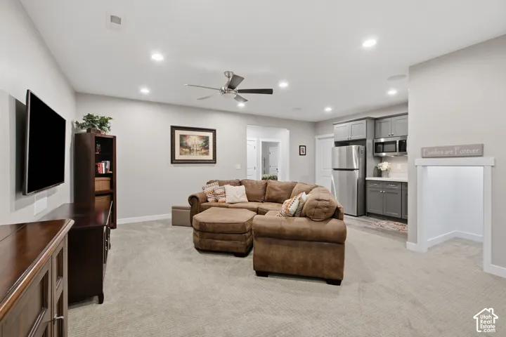 Recessed lighting, ceiling fan, and carpeted flooring in open-concept space with built-in cabinetry and stainless steel appliances