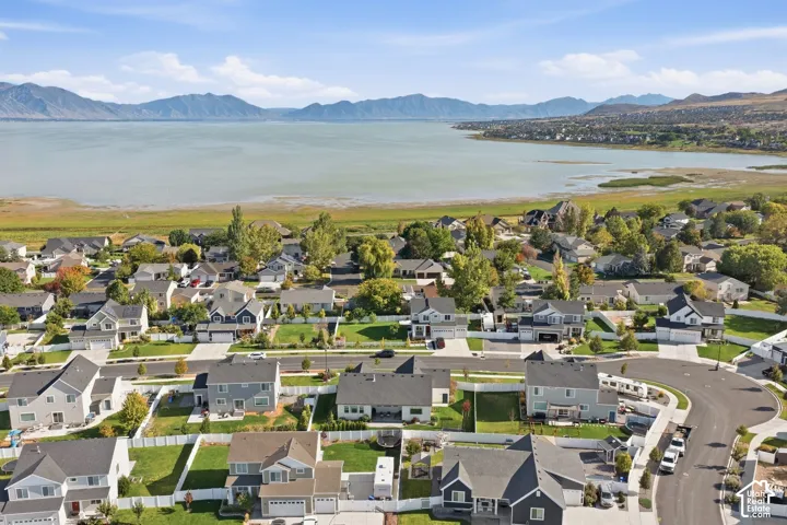Aerial perspective showcasing a residential development, a large body of water, and distant mountains