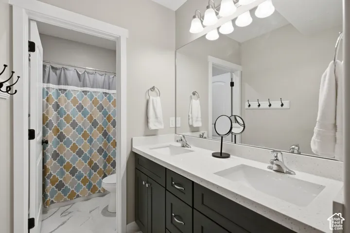 Dual vanity with white undermount sinks, light-toned countertop, and dark cabinetry