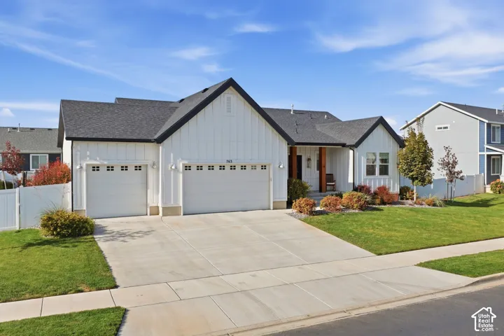 White board-and-batten exterior with dark trim and a dark shingle roof