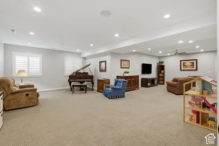 Recessed lighting, light-colored walls, carpeted flooring, window shutters, and a ceiling fan