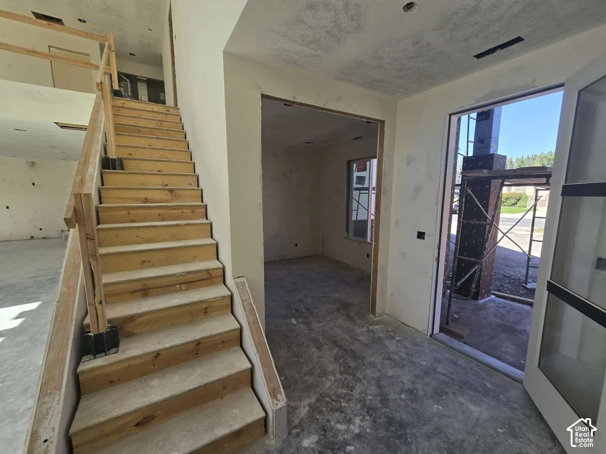 Open entry featuring a wood staircase with a wood railing