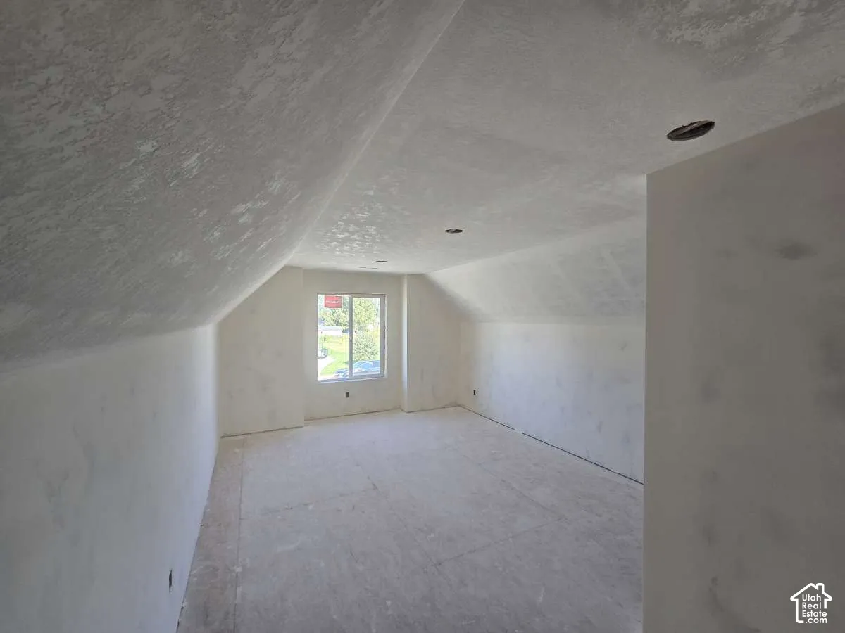 Sloping attic ceiling with recessed lighting and a window