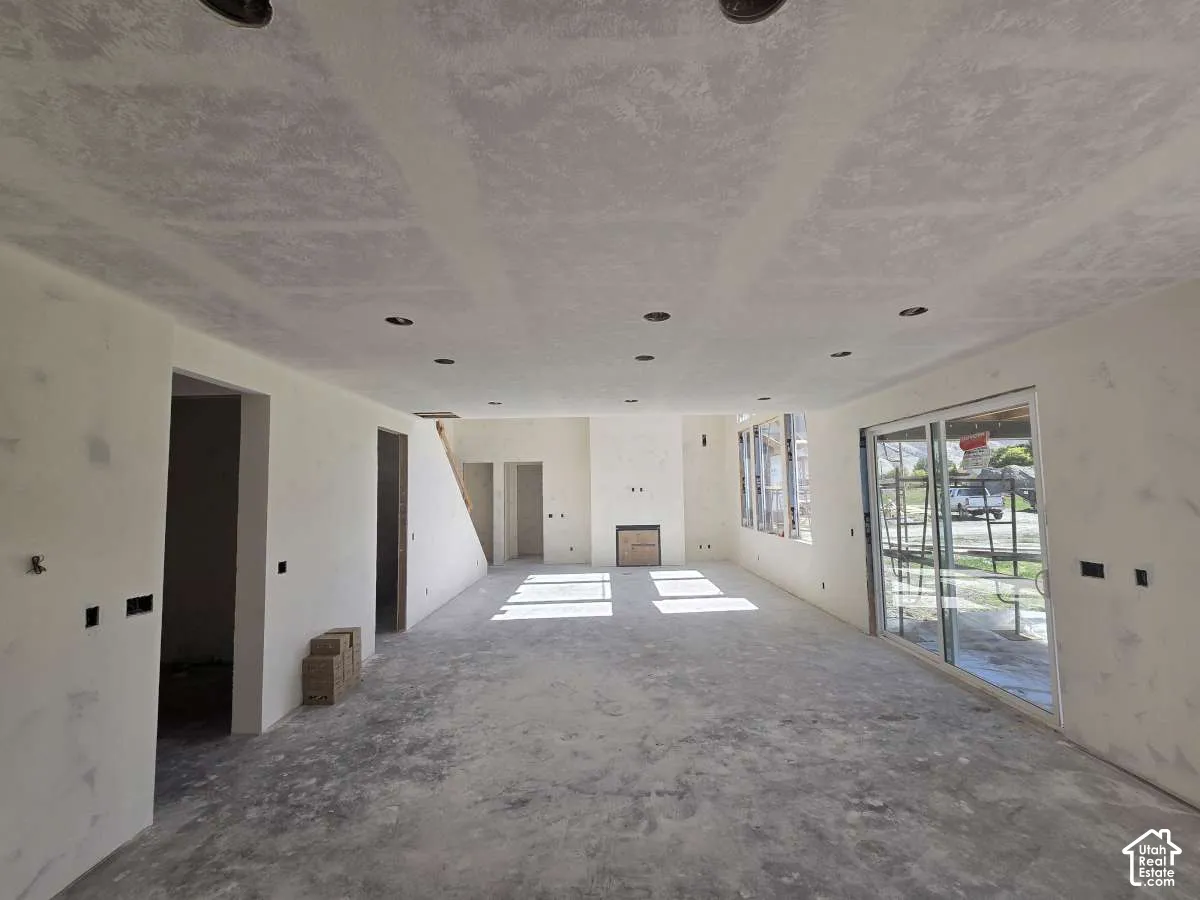 Expansive living area featuring recessed lighting, multiple windows, and sliding glass doors