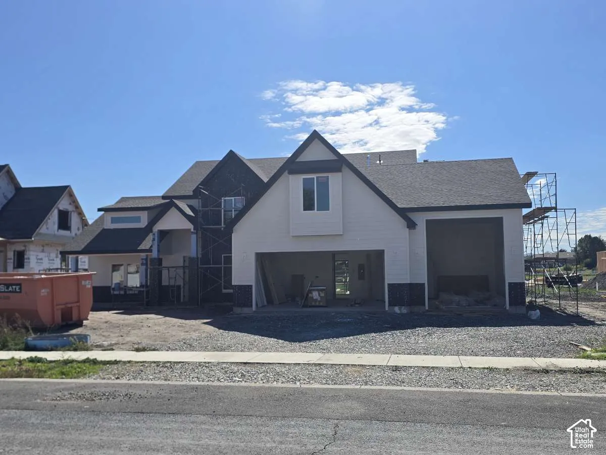 Attached two-car garage, dormer window, and asphalt shingle roof