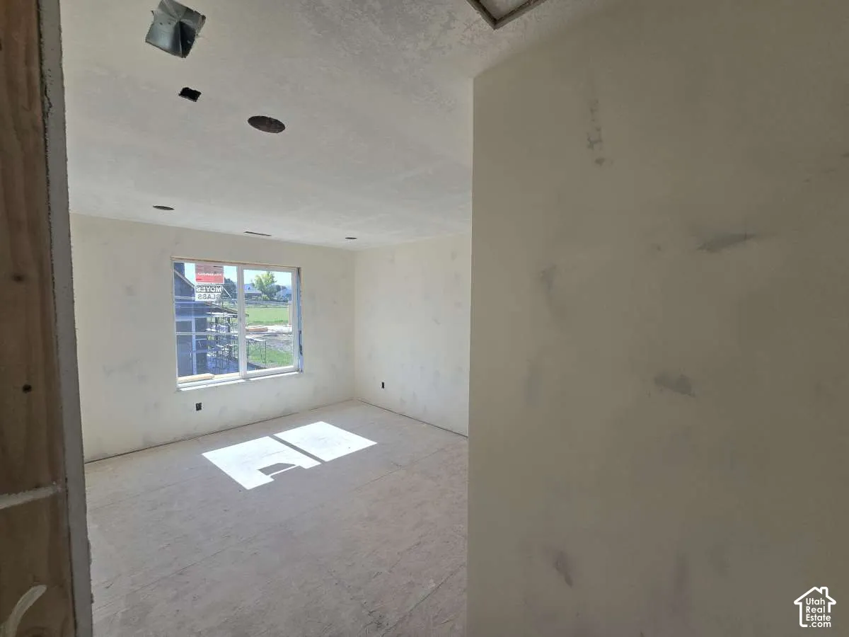 Unfinished interior space featuring a window, recessed ceiling lighting, and exposed ceiling ductwork
