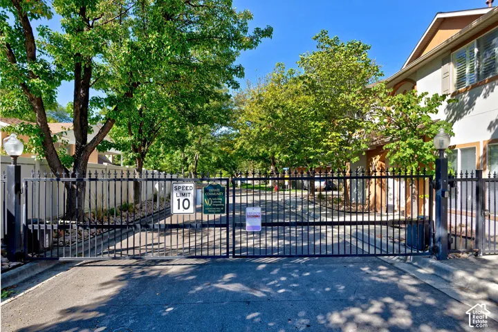 Gated entrance featuring wrought iron fencing and integrated lantern lighting