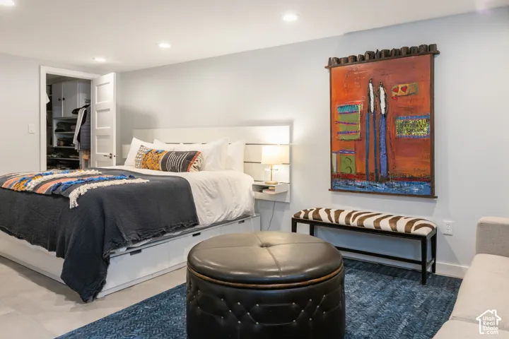Recessed lighting, wood-finish flooring, custom closet system, and a built-in bedside shelf with integrated lighting
