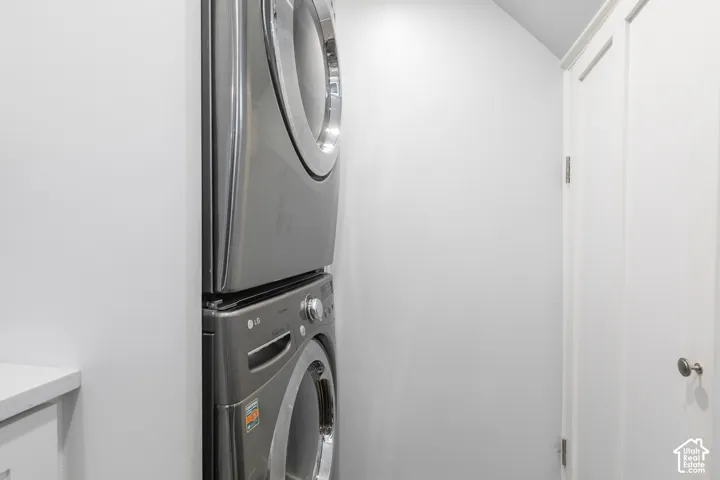 Stackable laundry appliances with a white countertop and white paneled doors