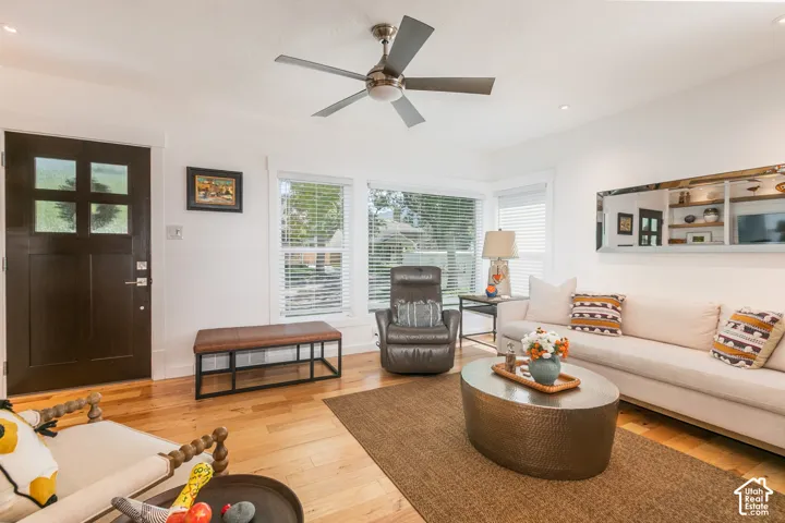 Hardwood flooring, bay windows, modern ceiling fan, recessed lighting, and a paneled entry door with frosted glass inserts