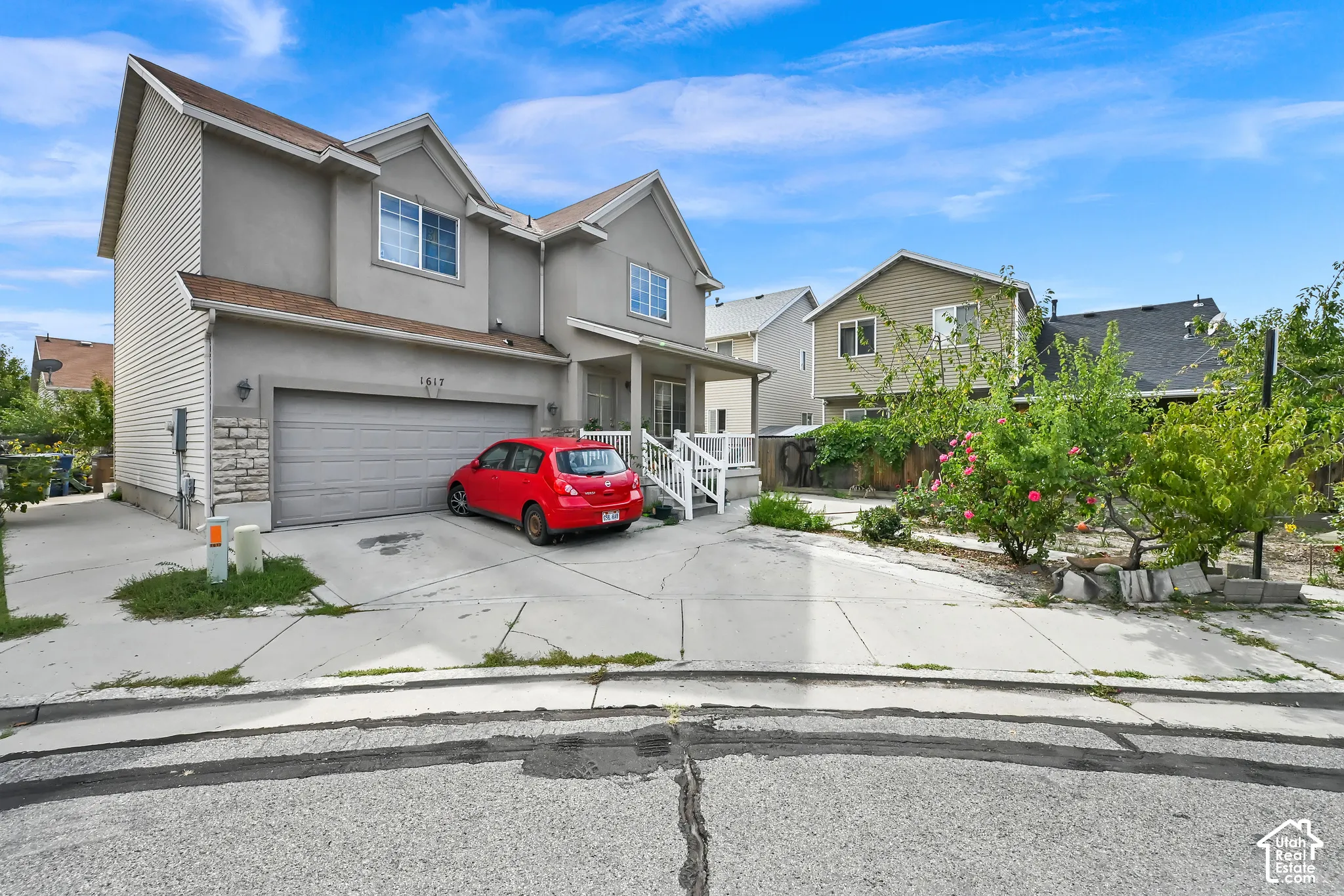 Two-story stucco and siding exterior with a stone veneer accent