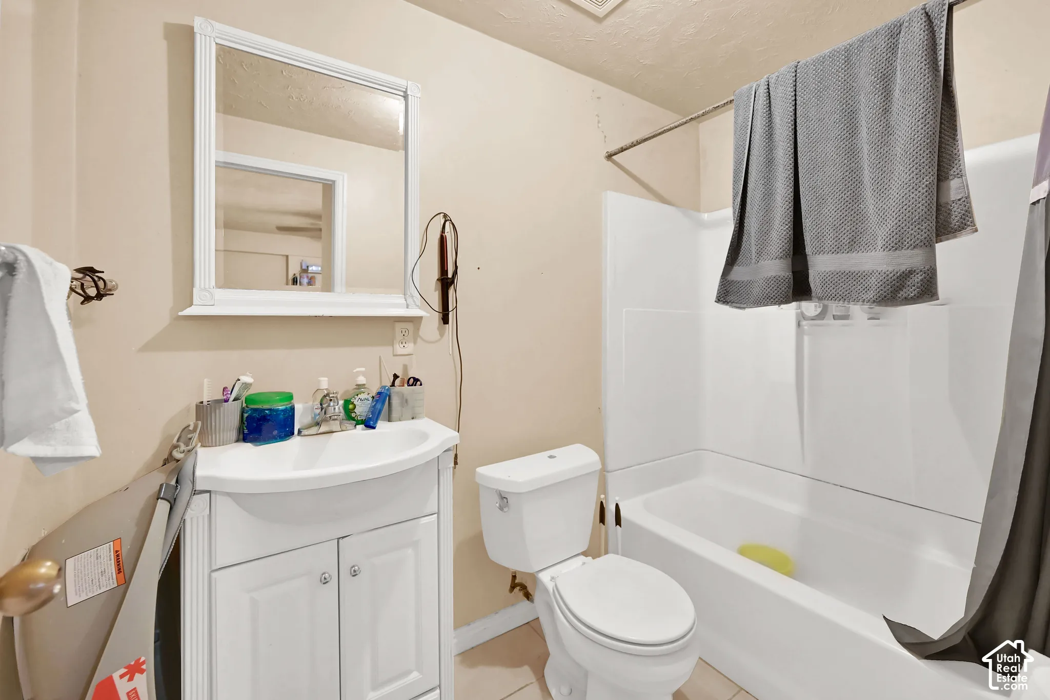 Bathroom with a white vanity, integrated sink, and white cabinetry