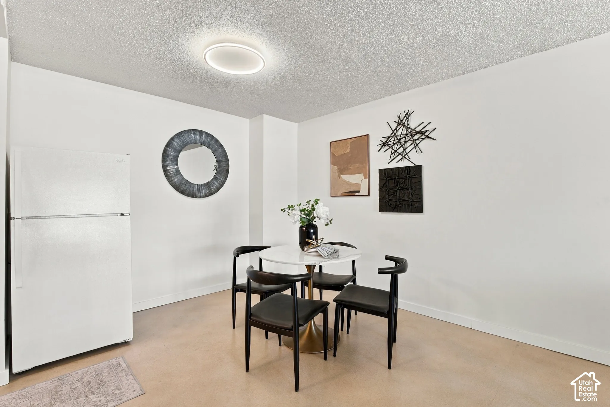Recessed ceiling light fixture, neutral flooring, white walls, and a built-in refrigerator