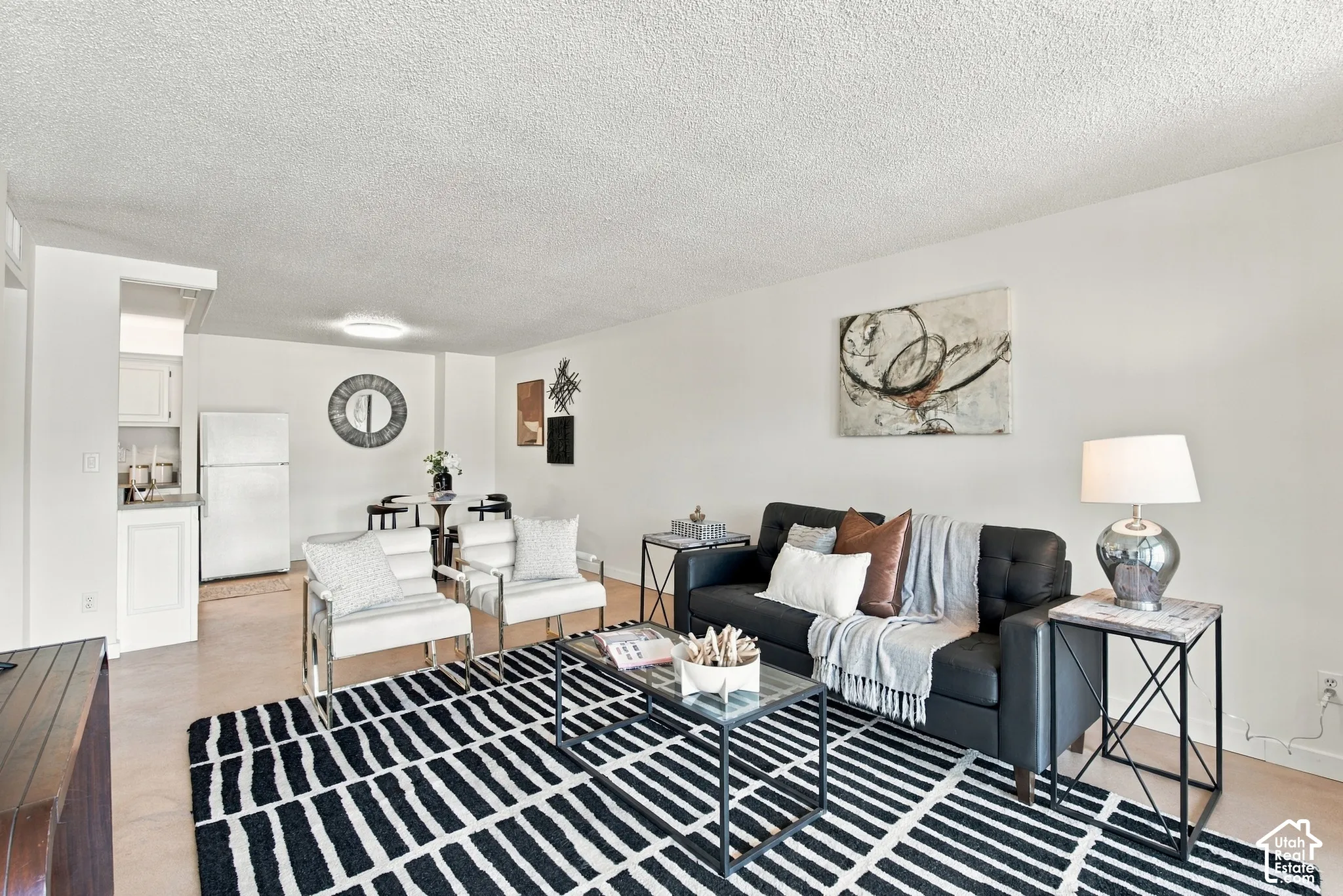 Open-concept living area with light-colored walls and overhead lighting