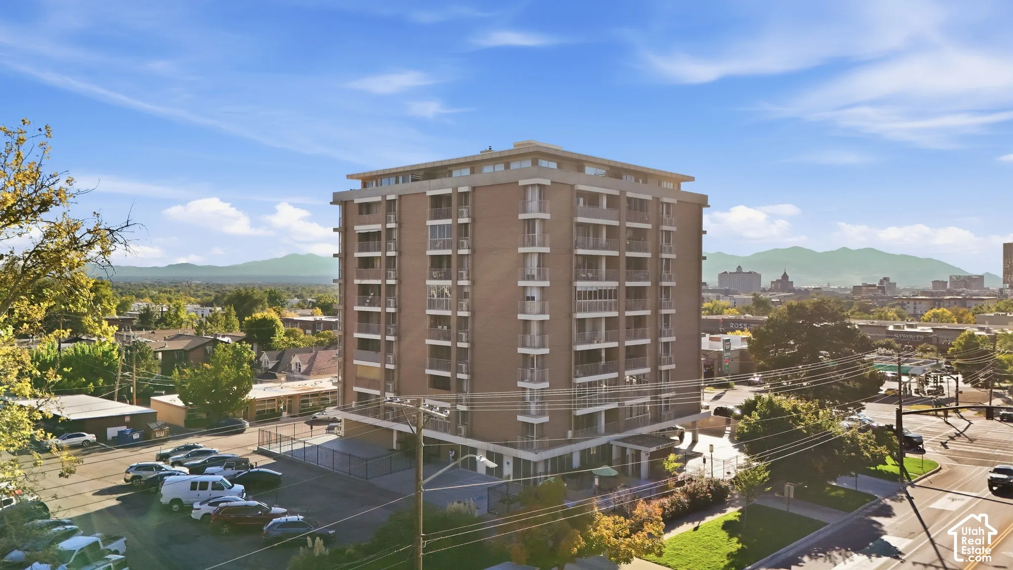 Multi-story building featuring a brick facade, numerous balconies with metal railings, and a flat roofline