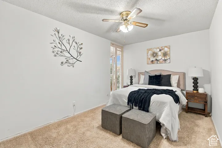 Carpeted flooring, ceiling fan with integrated lighting, and window with plantation shutters