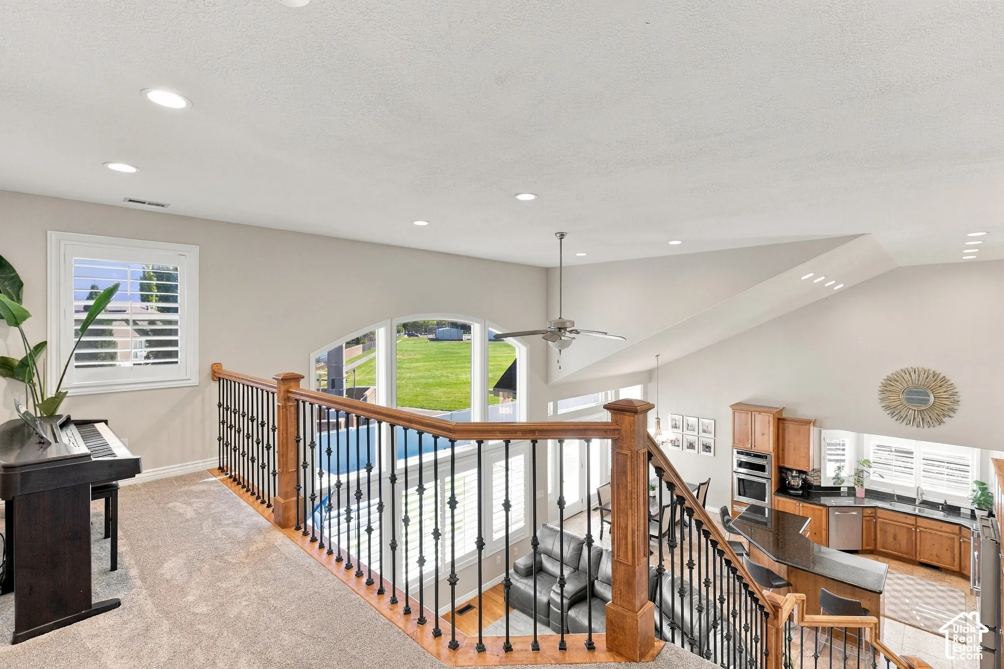 Carpeted landing with white window shutters and recessed lighting