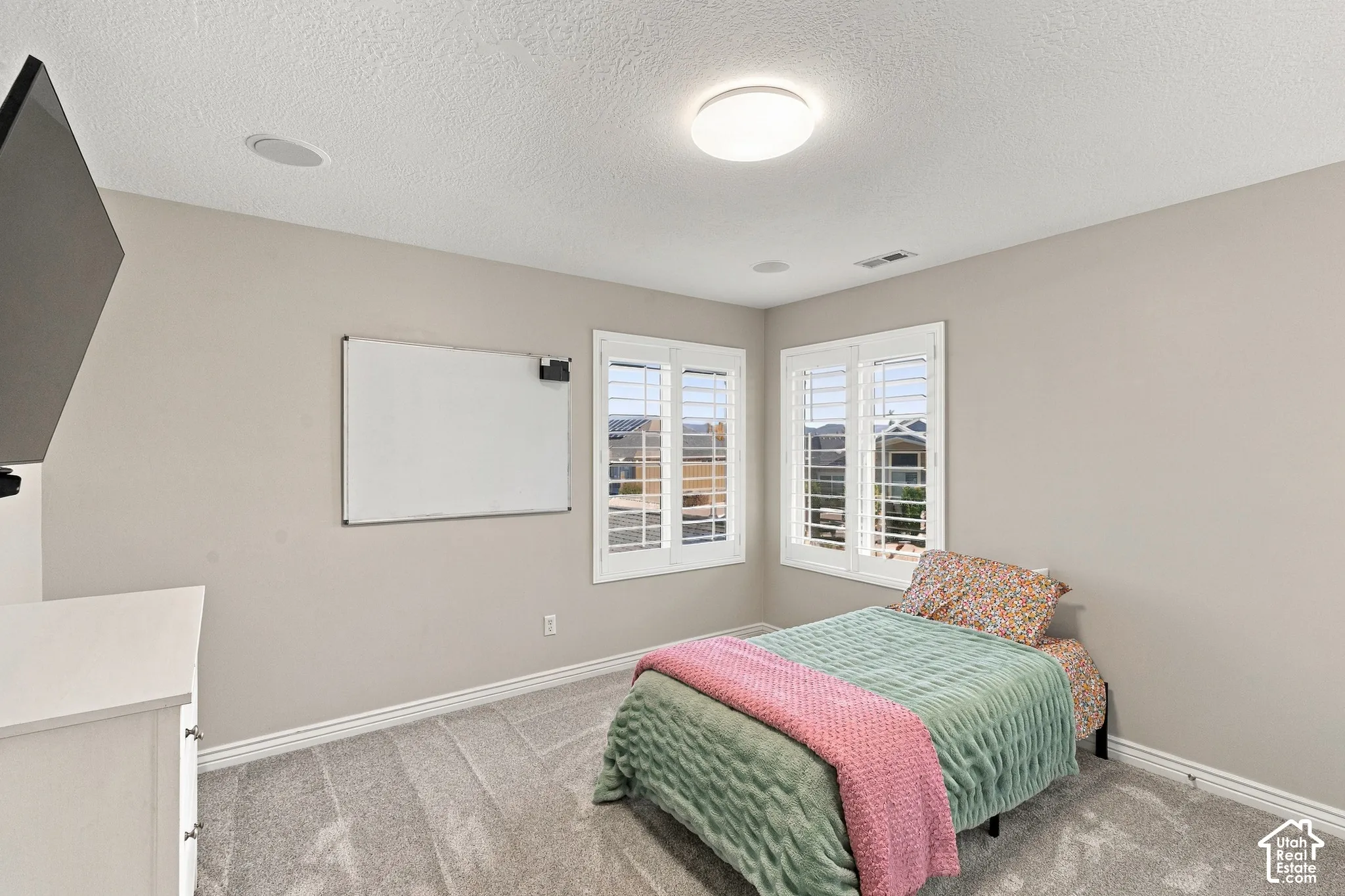 Recessed ceiling speakers, flush-mount ceiling light, plantation shutters, and light-tone wall paint