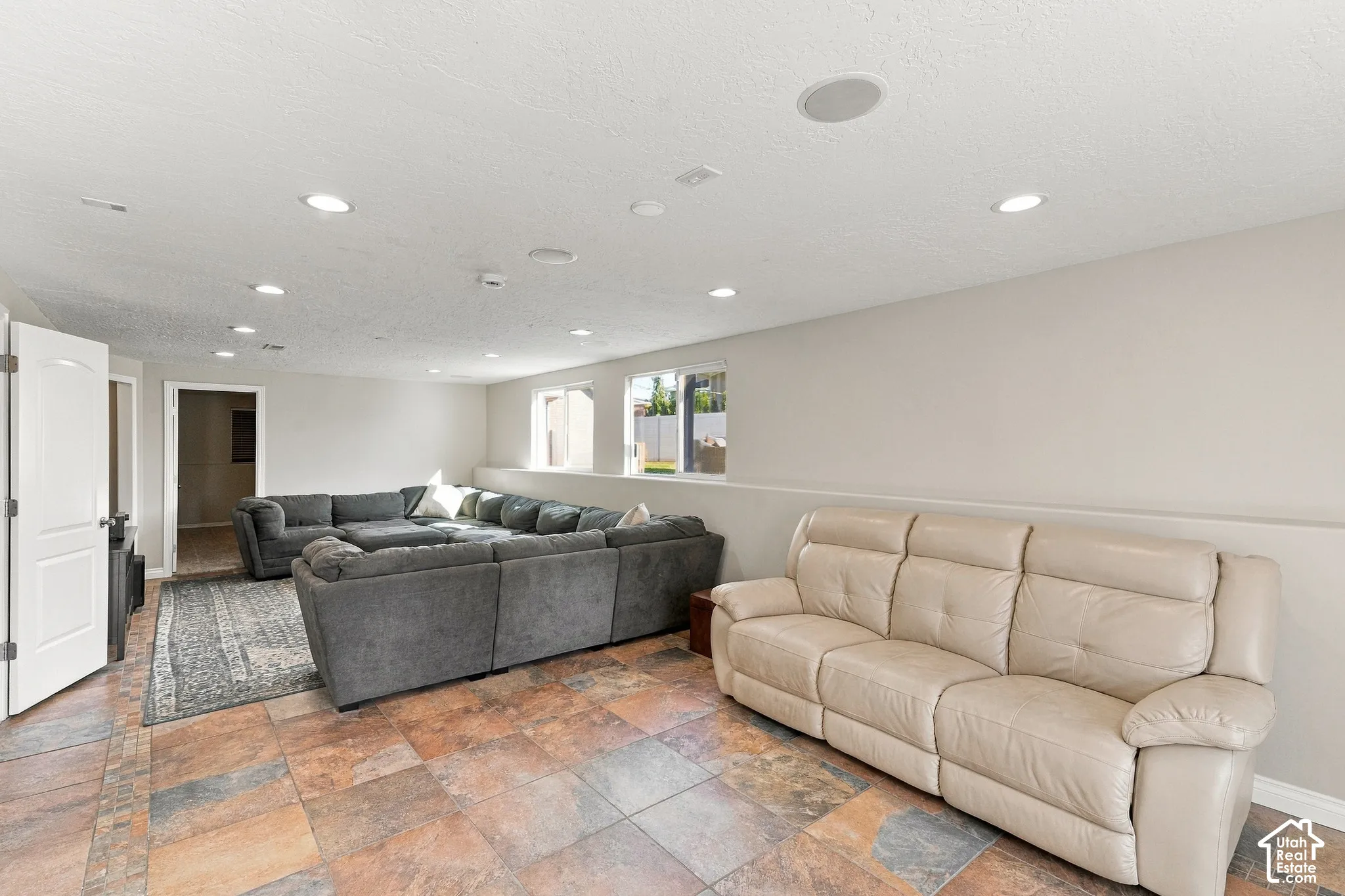 Spacious room featuring tile flooring, recessed lighting, and multiple windows