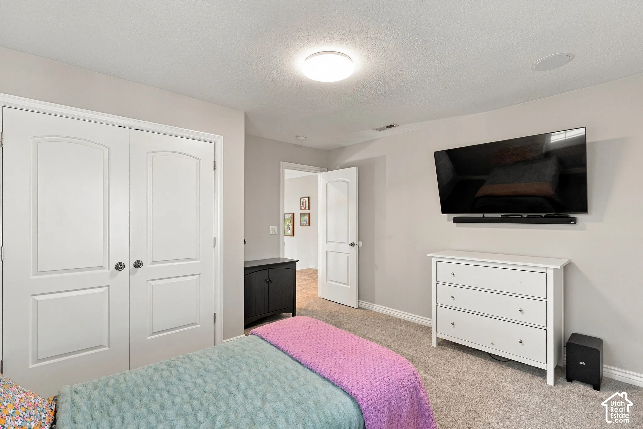 Carpeted flooring, white interior doors with arched paneling, and an integrated ceiling light fixture