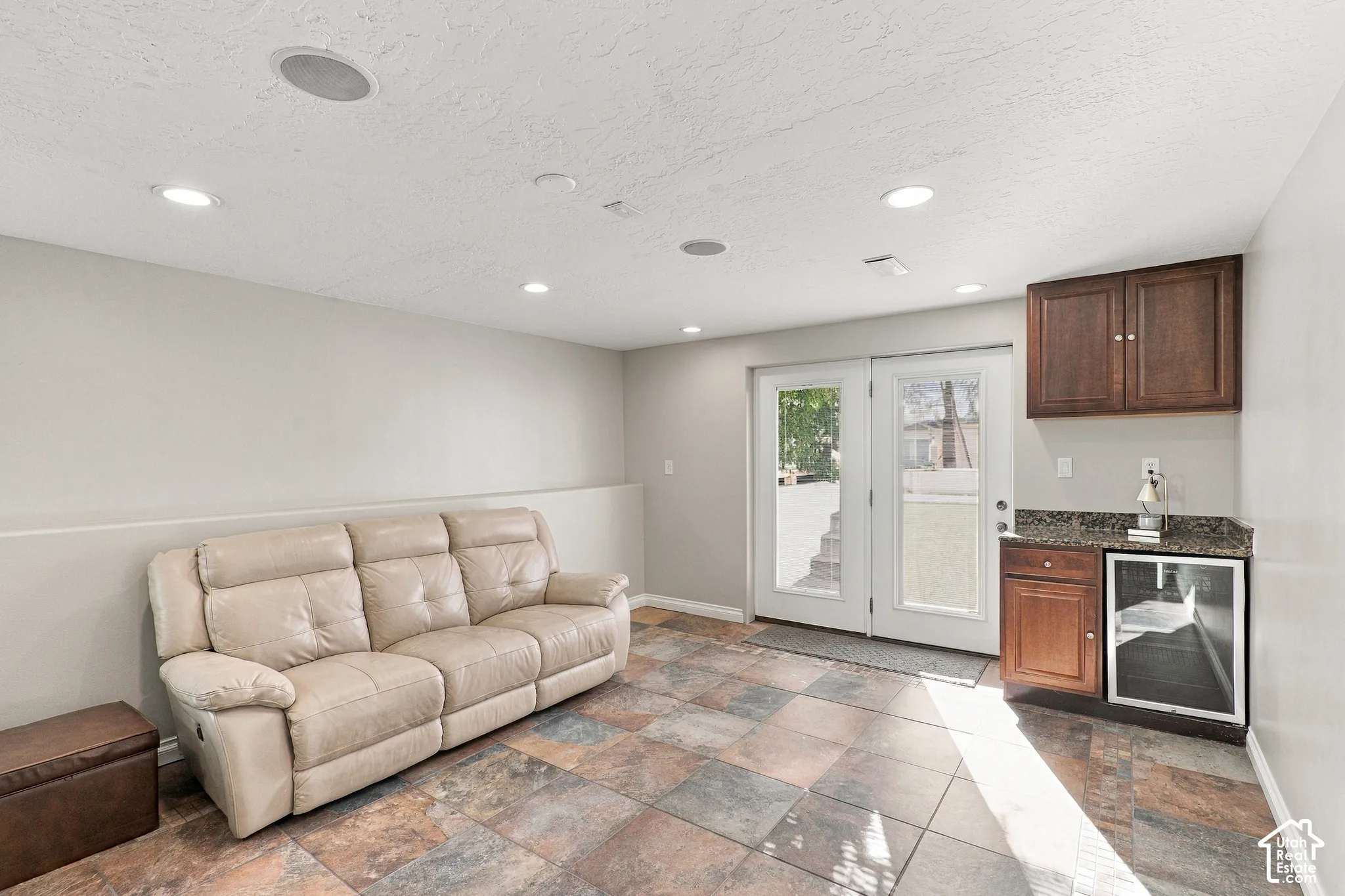 Recessed lighting, ceiling-mounted speakers, French patio doors, tile flooring, and built-in cabinetry with a beverage cooler