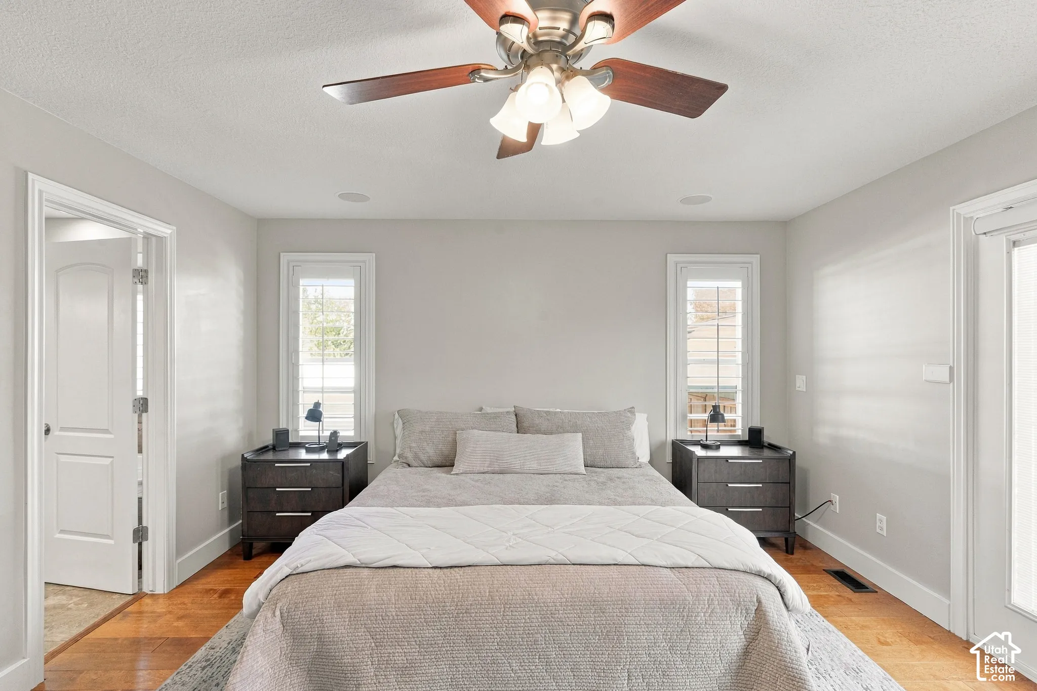 Wood-finish flooring, recessed ceiling speakers, and a ceiling fan with integrated lighting