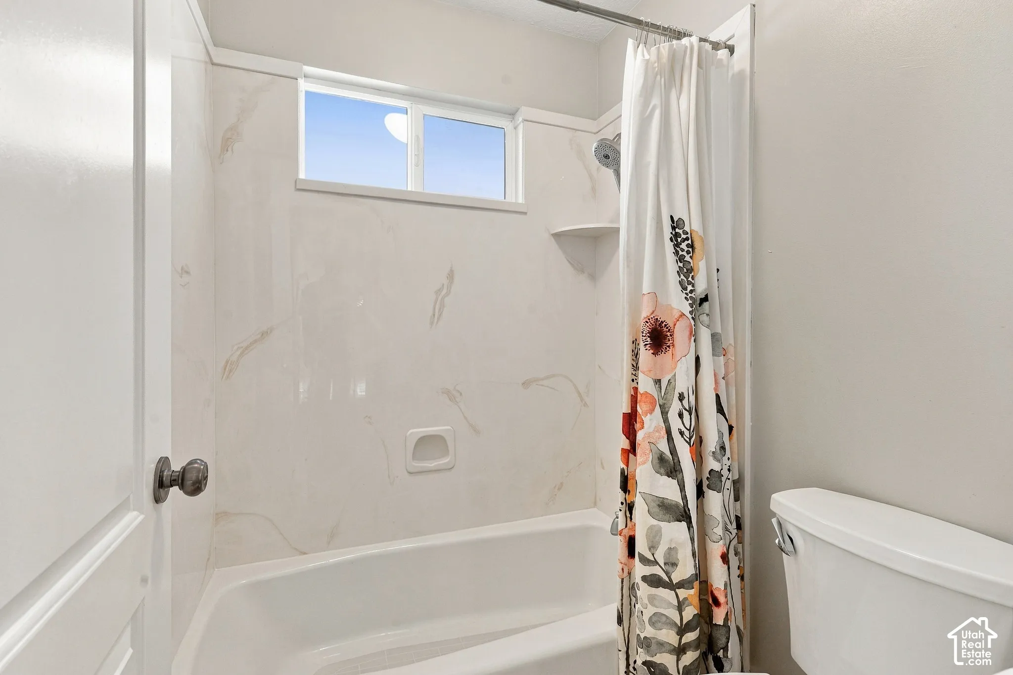 Bathtub with tile surround, built-in soap dish, and a window