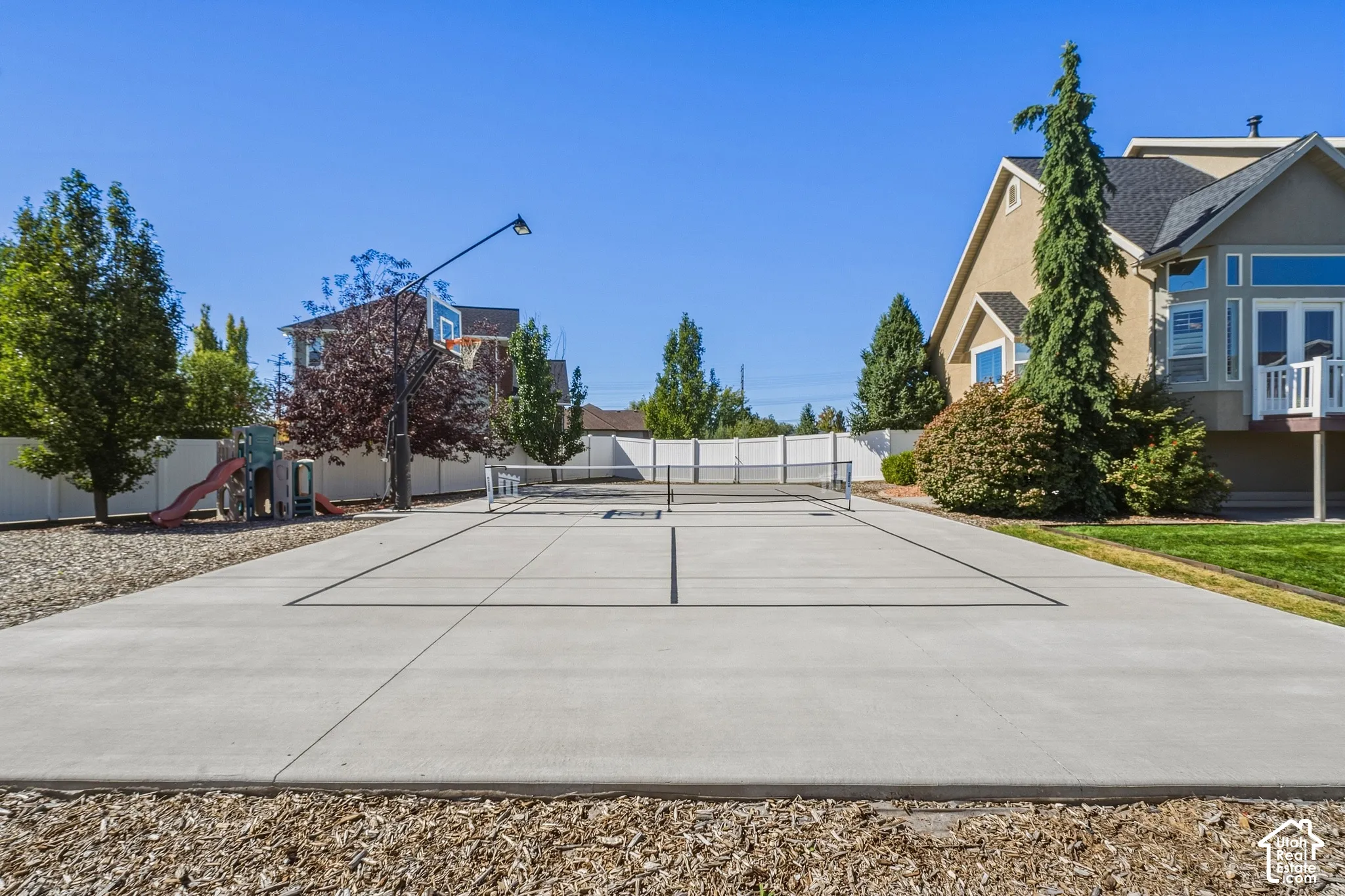 Concrete multi-sport court with basketball hoop and tennis net