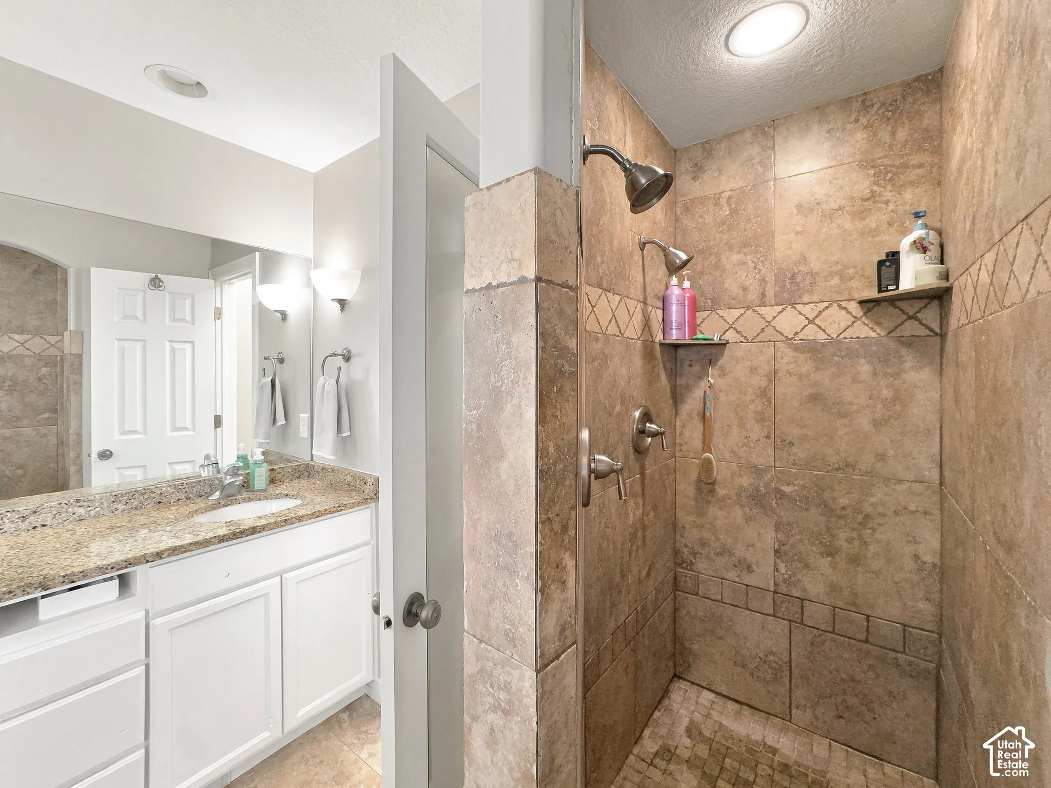 Tile-surround shower with a built-in corner shelf and a handheld showerhead