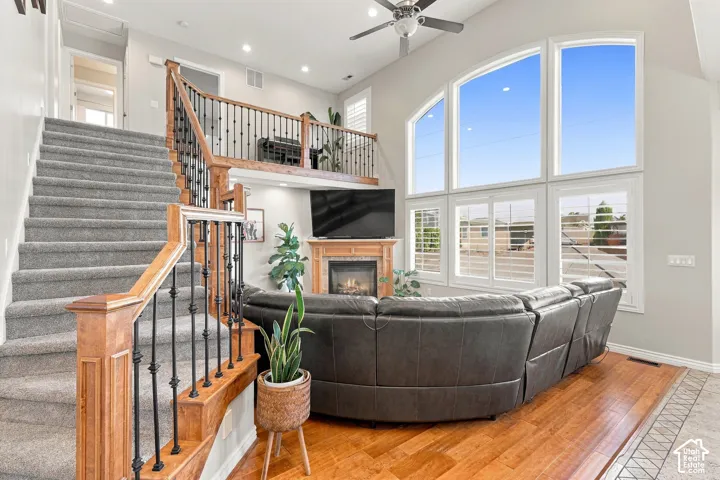 Two-story living area with a gas fireplace, a wood mantel, and an arched window arrangement