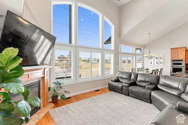 Two-story vaulted ceilings, wood-finish flooring, and a fireplace with a wood mantle